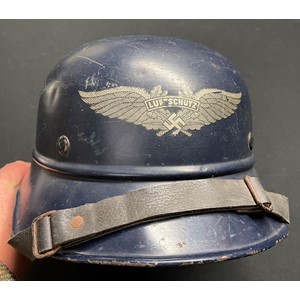 WW2 Third Reich Luftschutz M38 Steel Helmet. Original blue paint and decal. Complete with original liner, drawstring and chinstrap. Shell is marked "RL 2 - 38/28" along with original size and price decal. Size 56. Leather liner is also marked with the original lady owners name.