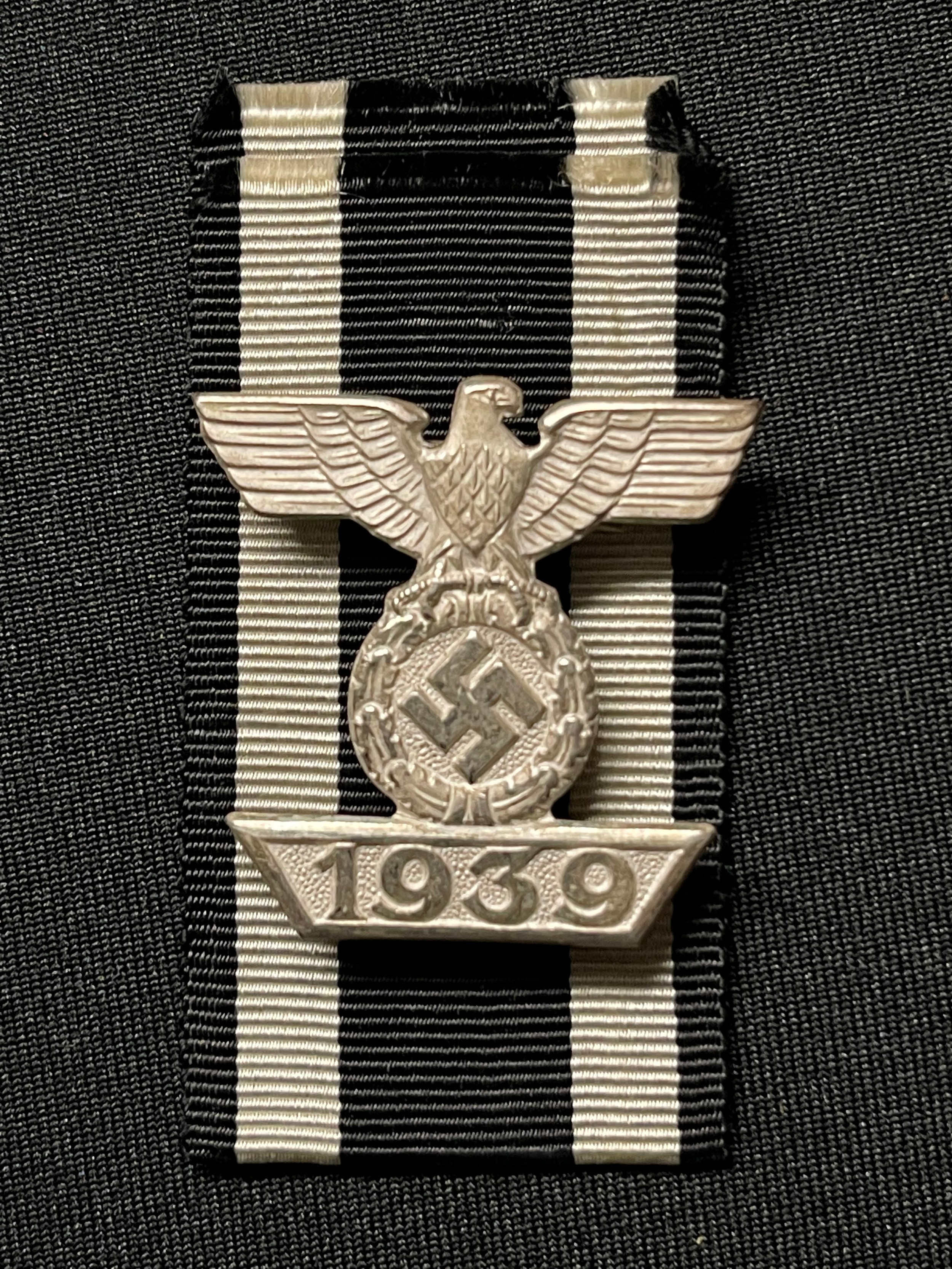 WW2 Third Reich 1939 Spange zum Eisernen Kreuzes 2er Klasse 1914. 1939 Bar to the Iron Cross 2nd class 1914. Complete with a section of original ribbon. No makers marks. War souvenirs of a British Veteran, Trooper RL Clay, Royal Armoured Corps, new to the market.