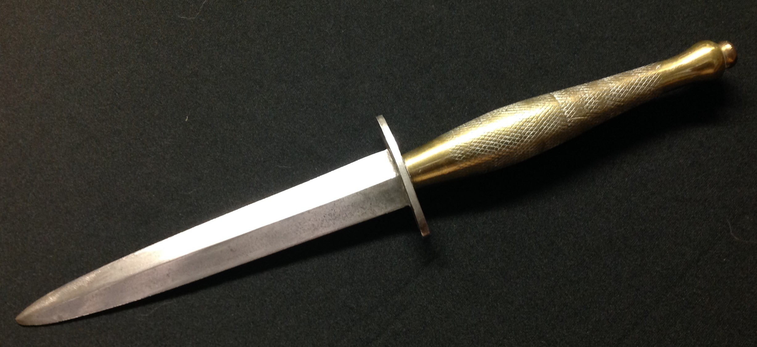 WW2 British 2nd pattern Fairbairn Sykes Fighting Knife with unmarked double edged blade, 145mm in length which has been heavily sharpened. No makers mark. Brass grip. Unmarked crossguard. Overall length 273mm. No scabbard.