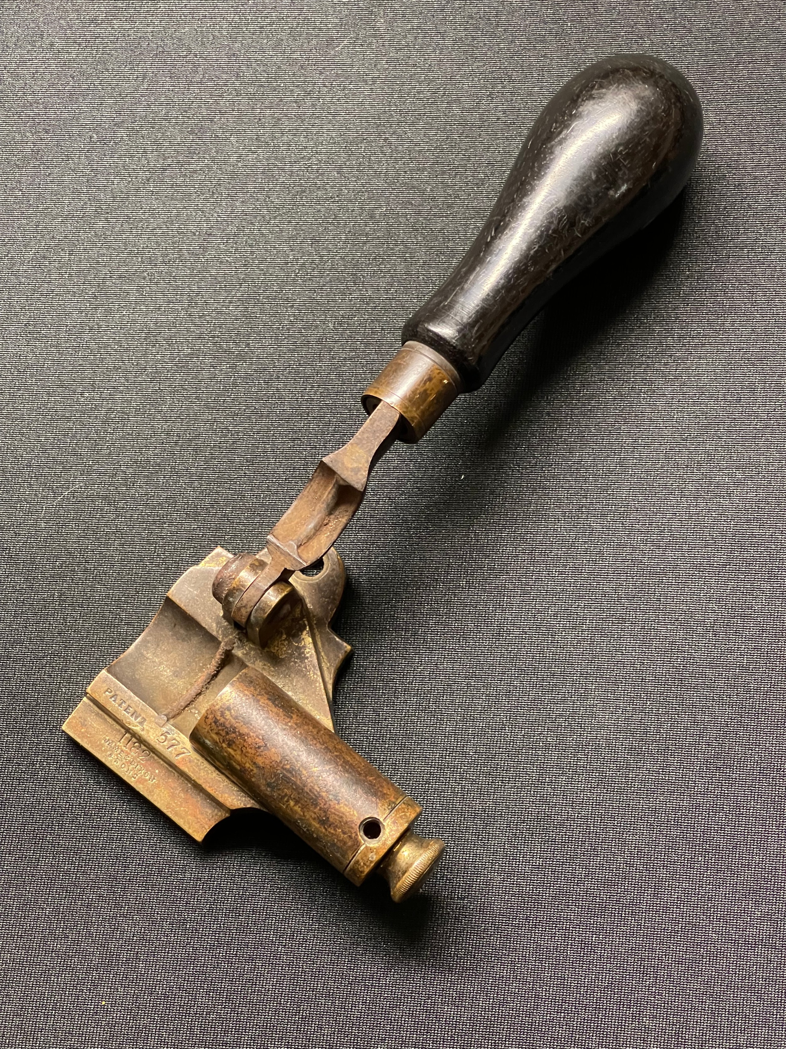 A 19th century patent James Dixon & Son #1182 ball cartridge creaser, Cal. 577. Brass body, colour hardened steel lever, turned ebony handle.