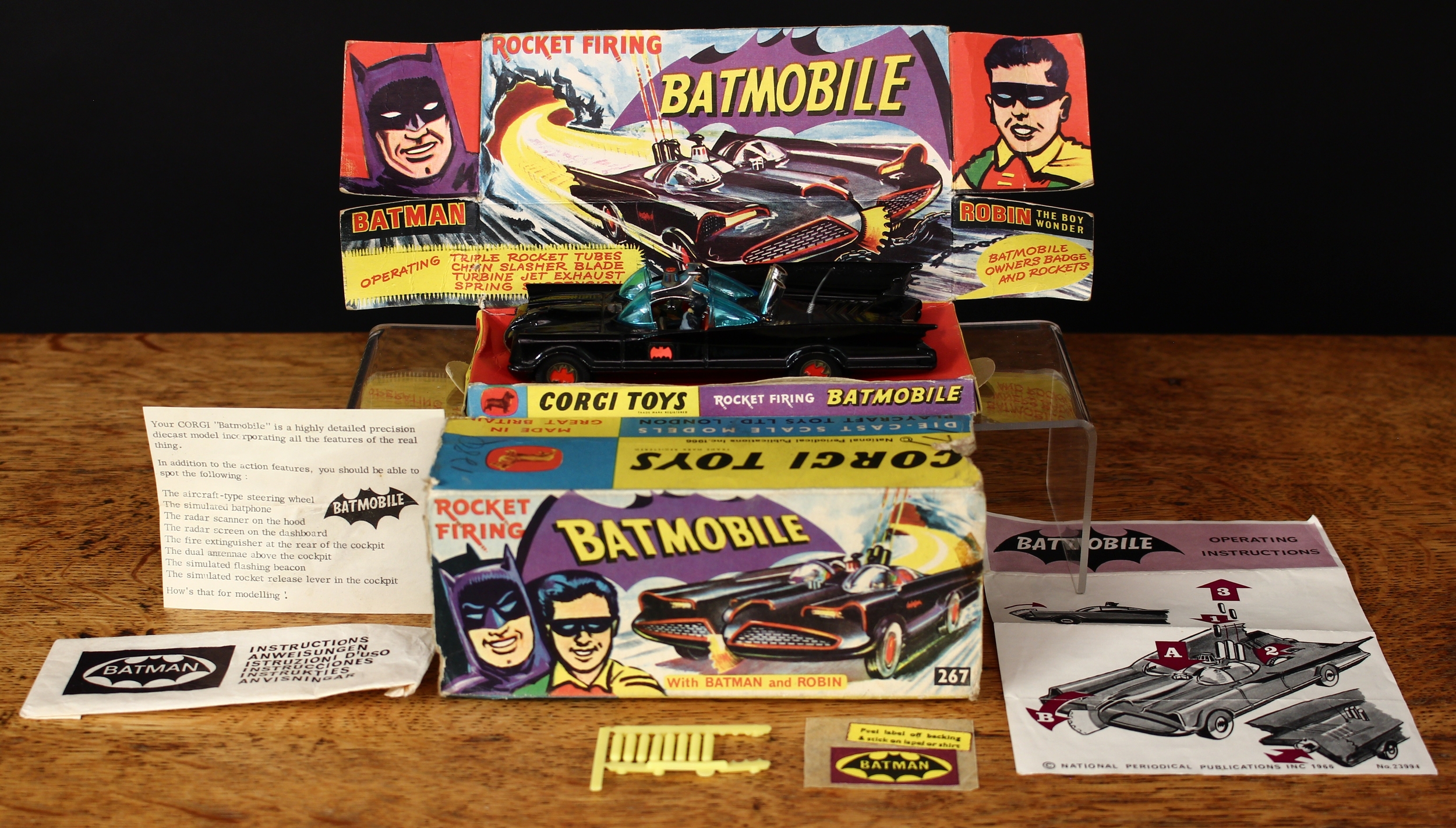Corgi Toys 267 Rocket Firing Batmobile, black body with black and red Bat decals to side doors, seated plastic figures of Batman and Robin to red interior, gold cast hubs with red Bat logo to centre, plastic aerial intact, boxed with original inner pictorial display stand, original ‘operating instructions’ in packet, literature slip, unused lapel/shirt self-adhesive badge on backing and eight yellow rockets on sprue