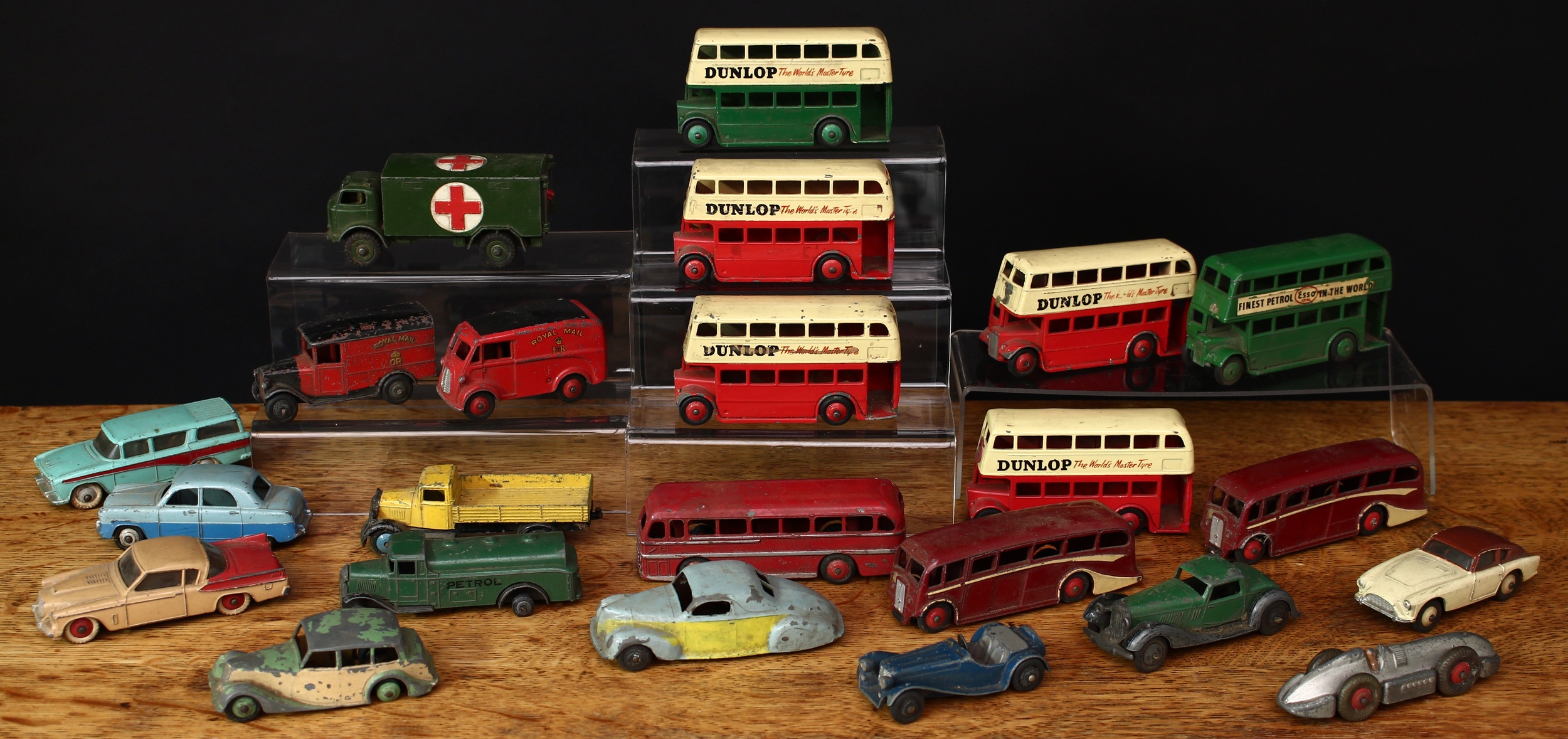 A collection of post-war unboxed playworn diecast models, mostly Dinky Toys, including 23e ‘Speed of the Wind’ racing car, silver body with tan driver; 36b green body with black running boards and arches, black ridged hubs; 172 Studebaker Land Cruiser, two tone beige and tan body, beige ribbed hubs; other unboxed diecast models including public transport buses, commercial vehicles and accessories (*60)