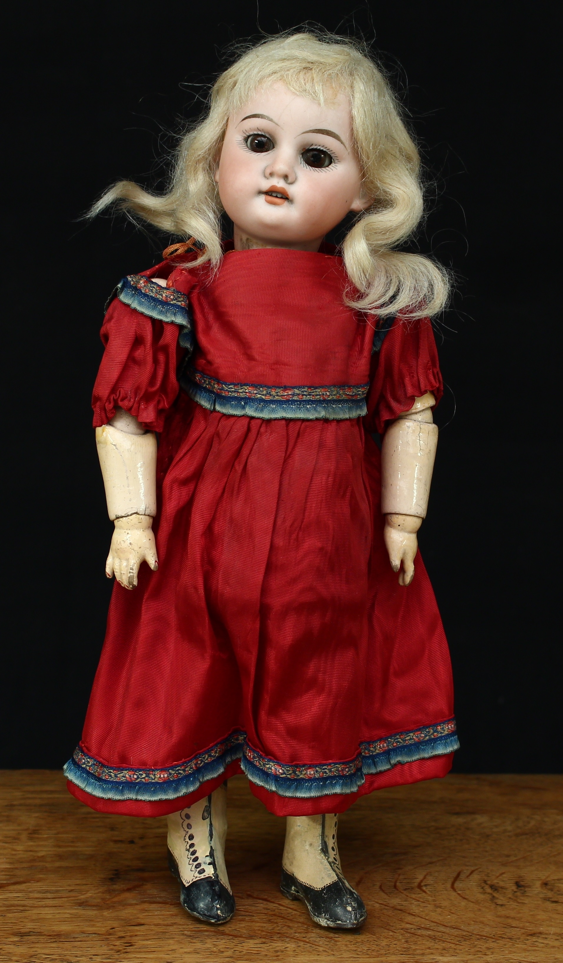An Armand & Marseille (Germany) bisque head and part ball jointed composition bodied Autoperipatetikos clockwork walking doll, weighted sleeping brown glass eyes, painted features including fine eyelashes and brown eyebrows, open mouth revealing teeth, blonde wig on a cardboard pate, impressed marks '1894. A.M. DEP MADE IN GERMANY4/0X', printed and painted tinplate body with clockwork mechanism, 30cm high