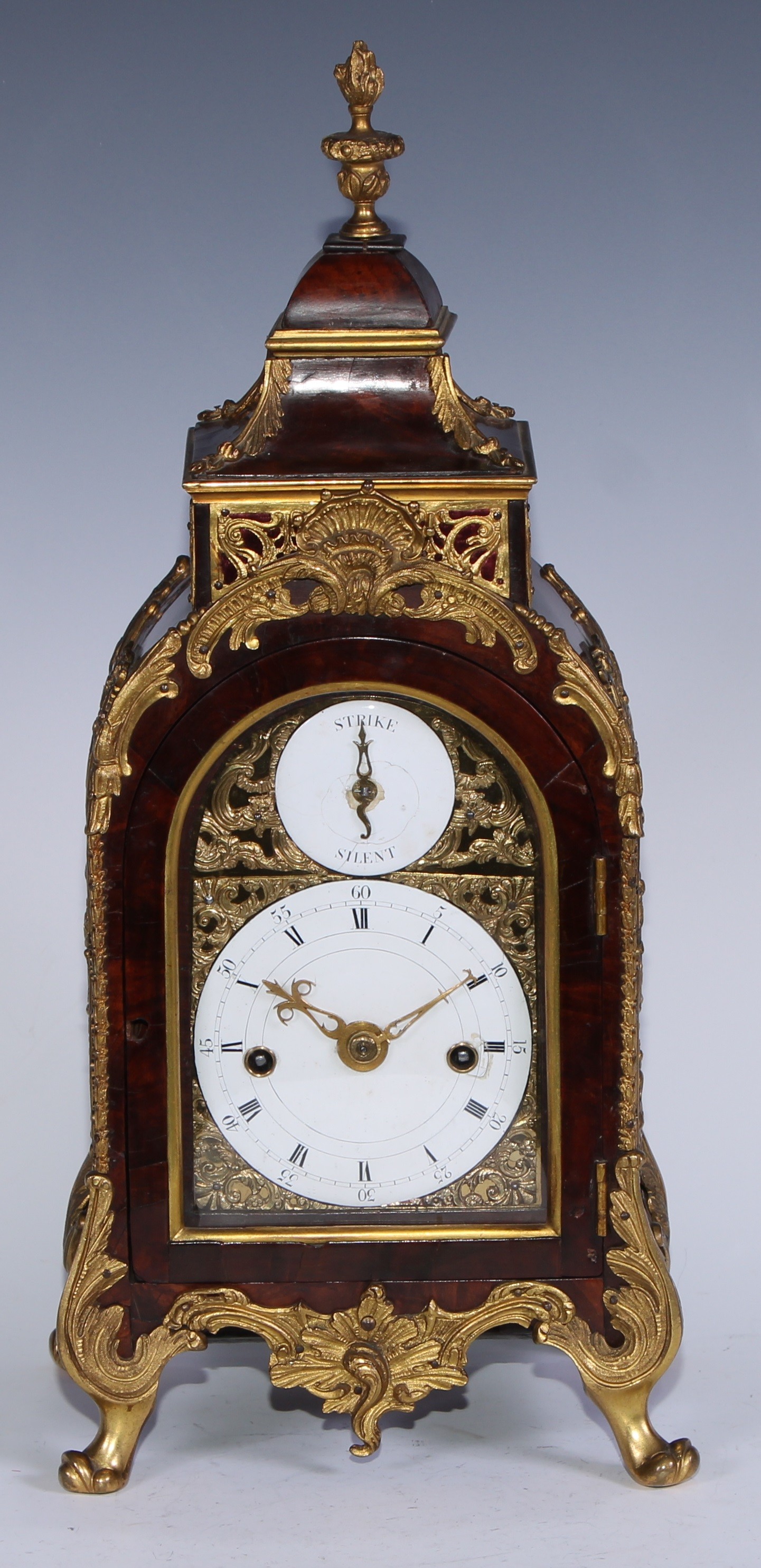 A George III ormolu mounted mahogany petite sonnerie table clock by Marriott, London, of small size, 9.5cm enamel dial with Roman and Arabic numerals and strike silent dial to arch, brass foliate spandrels, twin winding holes, the quarter striking 8 day movement with verge escapement striking on the hours on one bell and the quarters ting tang on two bells, the back plate engraved and chased with foliate scrolls and cartouche inscribed Marriott, London, the case with pagoda top, flame finial and pierced sides, acanths scroll feet, applied overall with ormolu leaves, scrolls and husks, 40cm high overall, c.1785  John Marriott, clock maker of Fleet Street, London was apprenticed until 1755 and free of the clock makers company from 1768 until his death in 1824. He made clocks for the Turkish and Chinese export market including many musical. A fine musical and automaton clock by Marriott is now in the Palace Museum, Beijing.