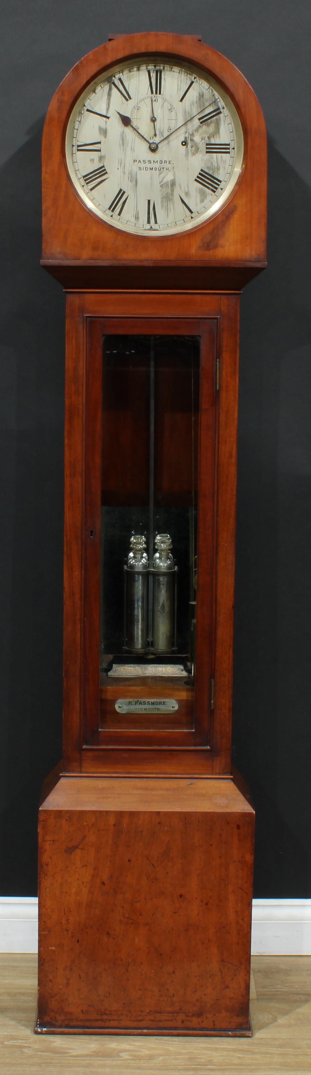 A Victorian mahogany regulator longcase timepiece, 30.5cm circular silvered dial inscribed Passmore., Sidmouth., Roman numerals, subsidiary seconds dial, single winding hole, deadbeat escapement, the case quite plain, glazed rectangular door enclosing a beat regulation plate and a plaque inscribed R. Passmore., Sidmouth., twin-tube mercury pendulum, single brass-bound weight, 188.5cm high, 42cm wide, 22.5cm deep, c.1890