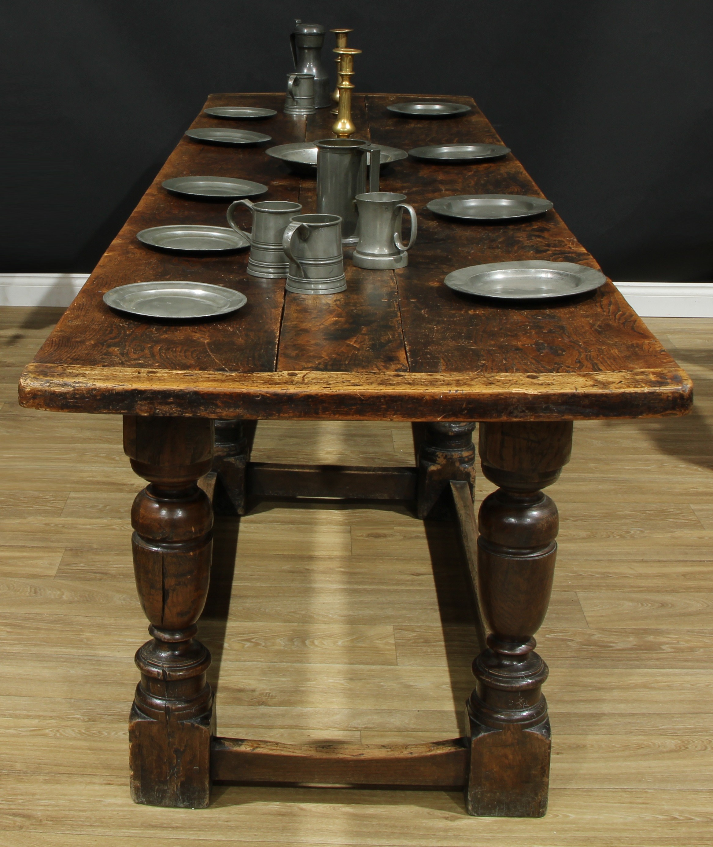 An '18th century' elm and oak refectory dining table, rectangular top, turned and blocked pillars, rectangular stretchers, 80cm high, 309cm long, 84.5cm wide, incorporating period timbers