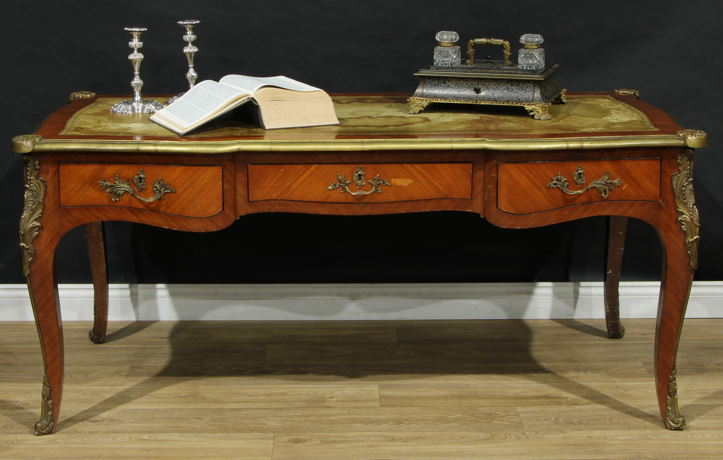 A large French gilt metal mounted kingwood bureau plat, shaped serpentine top with inset tooled and gilt leather writing surface above three frieze drawers, blind to verso, cabriole legs, 78cm high, 170cm wide, 82cm deep, first-half 20th century