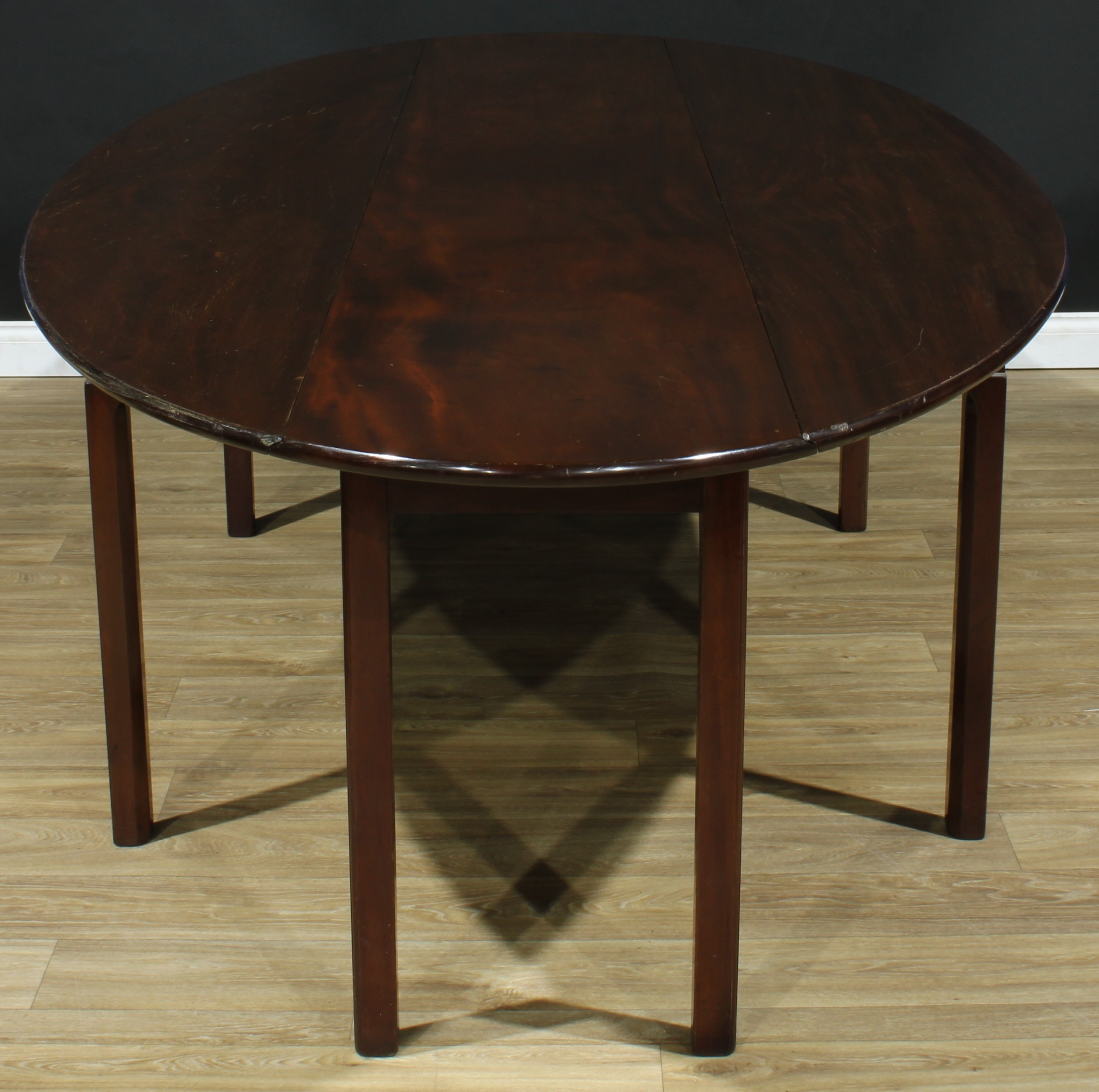 An Irish mahogany wake table, oval top with fall leaves, partially moulded and chamfered square legs, 76.5cm high, 297.5cm long, 51.5cm opening to 139cm wide, 20th century