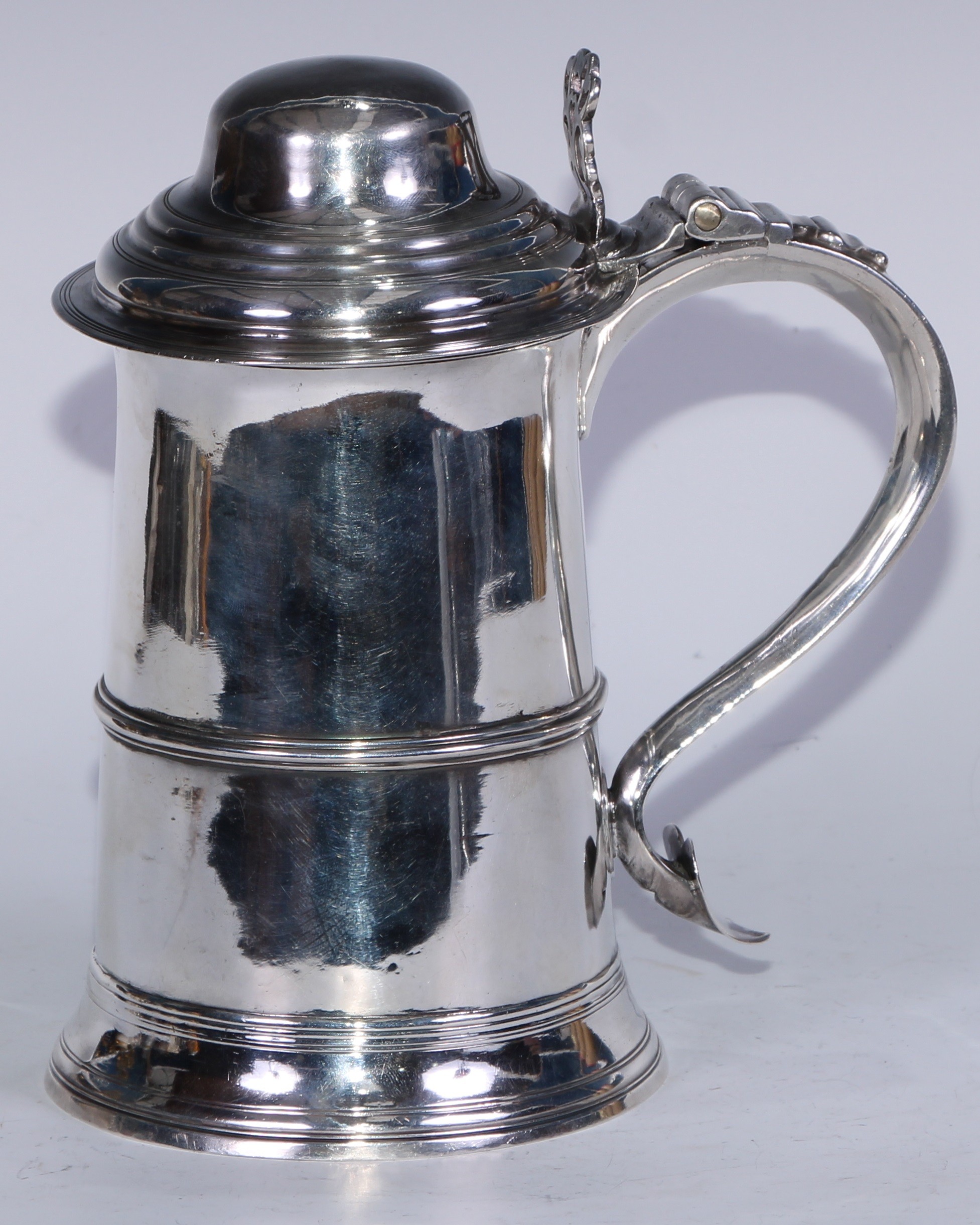 A George III silver tankard, hinged domed cover with chairback thumbpiece, scroll handle with heart shaped terminal, three-quarter gallery, skirted base, 22cm high, London 1792, 798g