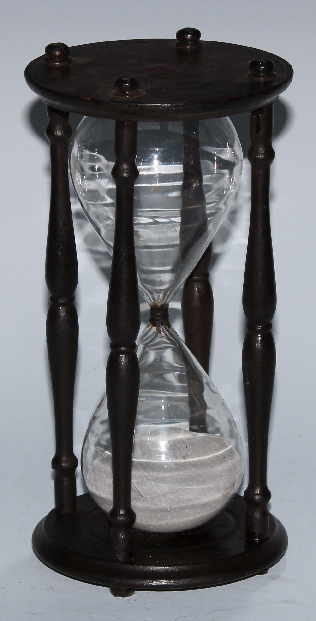 A sand glass, the ends decorated with sun-in-splendour and signs of the Zodiac, 24cm high