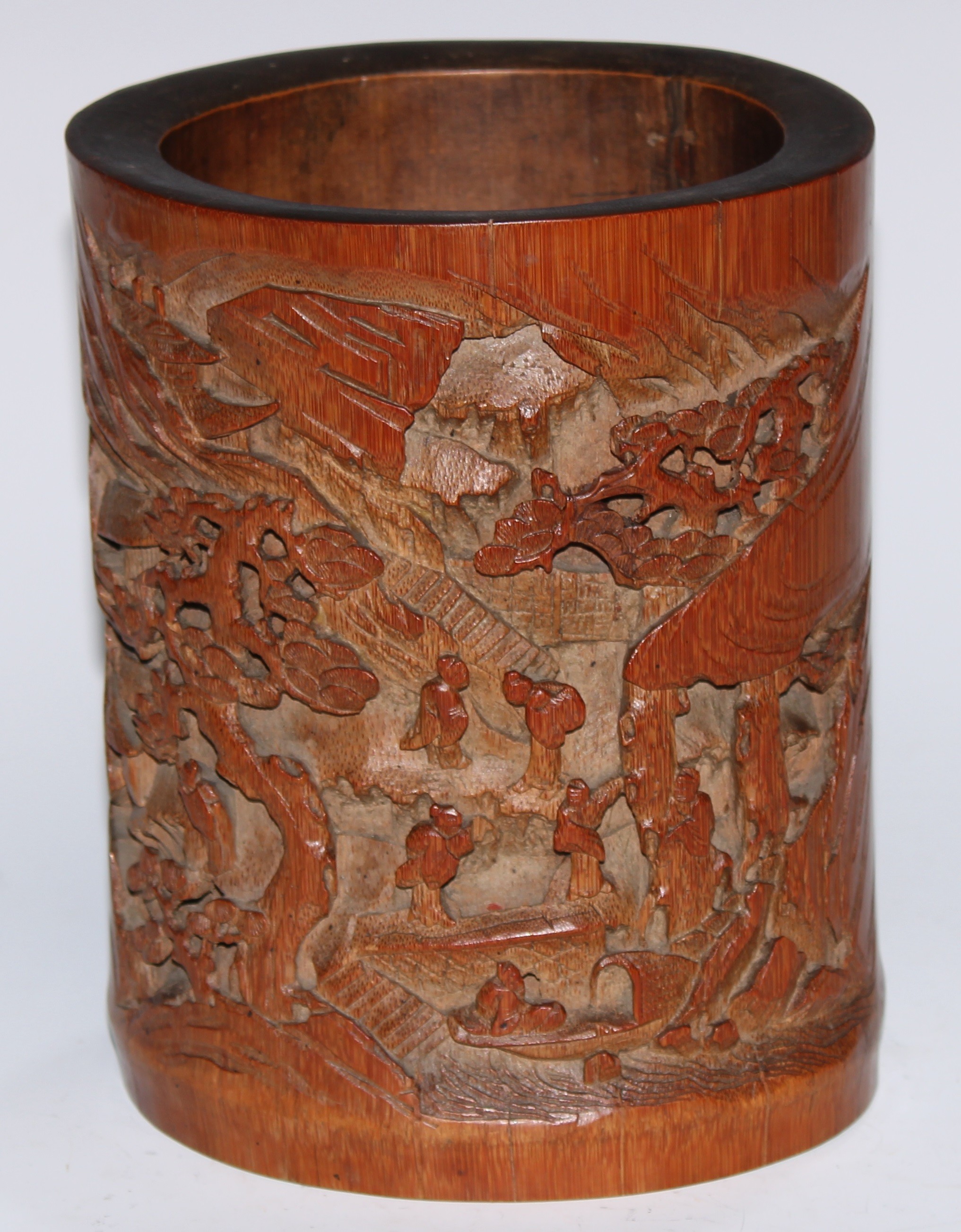 A Chinese bamboo bitong brush pot, well-carved in relief with figures in a monumental landscape, 18cm high, c. 1900