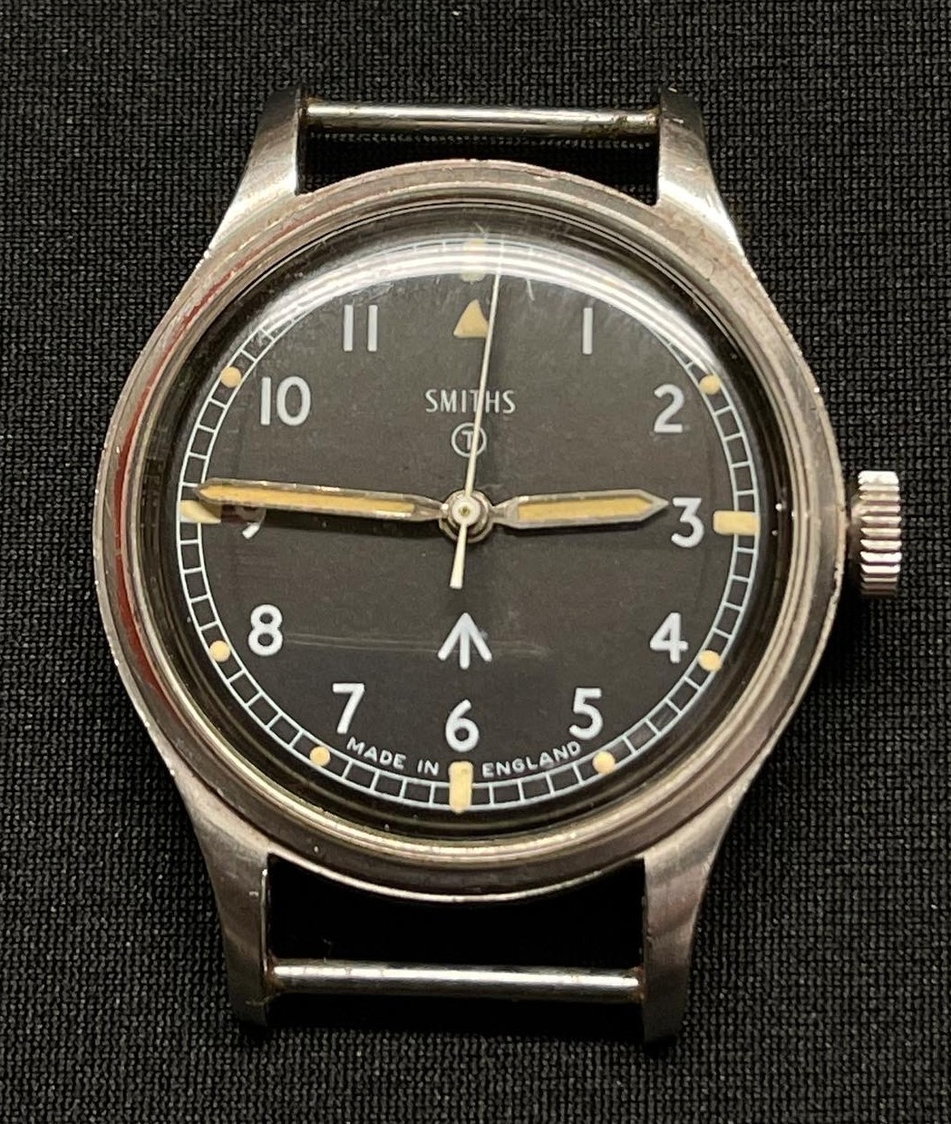 British Army Issue W10 Wristwatch by Smiths. Case is marked W10/6645-99-961-4-45 along with WD Broad Arrow and 5522/68. Black dial with Arabic numerals. Luminous hands and marks to numbers. Marked to dial "Smiths" "T" plus WD Broad Arrow and "Made in England".