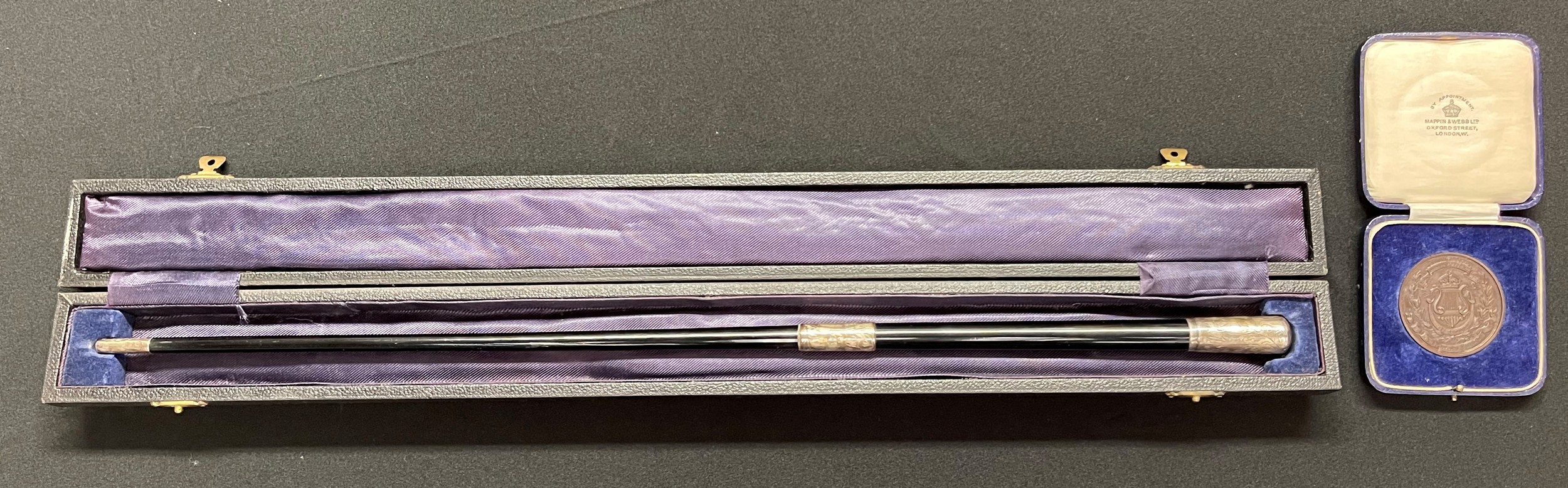 A cased British Army conductor's baton, silver mounted, inscribed "Presented by WO's, S/Sgts & Sgts to Lieut FL Statham Director of Music, RMA Sandhurst, February 1948: an accompanying Bronze medalalion from the Royal Military School of Music awarded to Student FL Statham, 2nd Royal Scots for best conductor, 1933. (2)