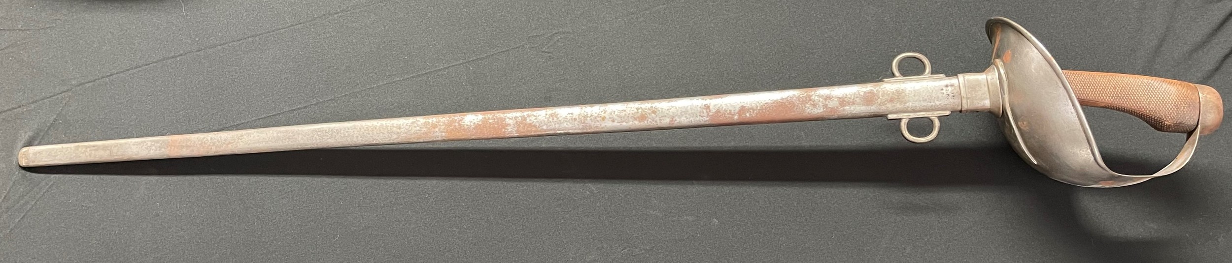 WW1 British 1908 Pattern Cavalry Trooper's Sword with 890mm long single edged fullered blade. '8-15 dated blade. Wooden grip. Overall length 109cm. Complete with steel scabbard with twin suspension rings dated '15. Unit markings to scabbard for the 20th Hussars, "7.19 20.H 12". Both sword and scabbard are well marked with various inspection stamps.