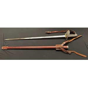 WW2 British Army Officers 1897 Pattern Sword with etched decorated fullered blade 822mm in length with proof mark, and "Wilkinson Sword Co. Ltd, London" makers mark. Spine of blade marked "Made in England" along with serial number 67988. White felt buffer pad. Wire bound shagreen grip. Guard marked "GRI". Overall length 990mm. Complete with original leather knot. Complete with leather covered scabbard and leather frog for the Sam Brown Belt.