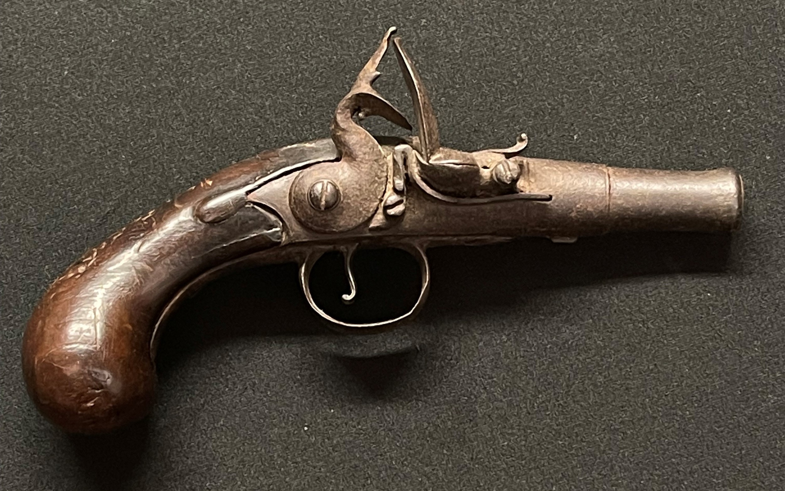 Flintlock Pocket Pistol with 75mm long barrel, bore approx 12mm, overall length 175mm. Working action. No makers marks. Cock jaw and screw missing. Section 58 (2), no licence required.