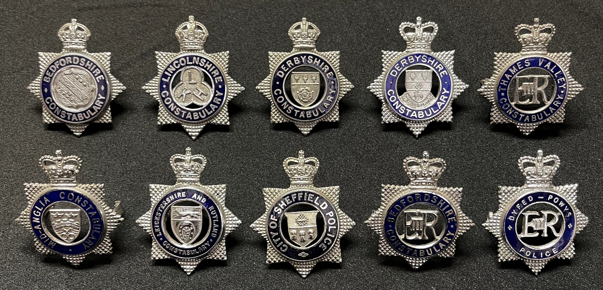 A collection of Police Officers cap badges to include: Kings Crown Derbyshire Constabulary: Kings Crown Lincolnshire Constabulary: Kings Crown Bedfordshire Constabulary: Queens Crown Dyfed-Powys Police: Queens Crown Derbyshire Constabulary: Queens Crown Mid Anglia Constabulary: Queens Crown Leicestershire & Rutland Constabulary: Queens Crown City of Sheffield Police: Queens Crown Thames Valley Police: Queens Crown Bedfordshire Constabulary . (10)