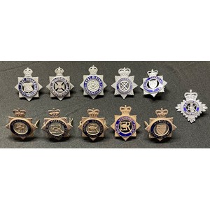 A collection of Police Officers cap badges to include: Kings Crown West Riding Constabulary: Kings Crown Wiltshire Constabulary: Kings Crown East Sussex Constabulary: Queens Crown Norfolk Constabulary: Queens Crown Merseyside Police: Queens Crown South Yorkshire Police: Queens Crown Greater Manchester Police: Queens Crown West Yorkshire Metropolitan Police: Queens Crown Liverpool & Bootle Constabulary: Queens Crown Cheshire Constabulary: Queens Crown HM Prison Swervice. (11)