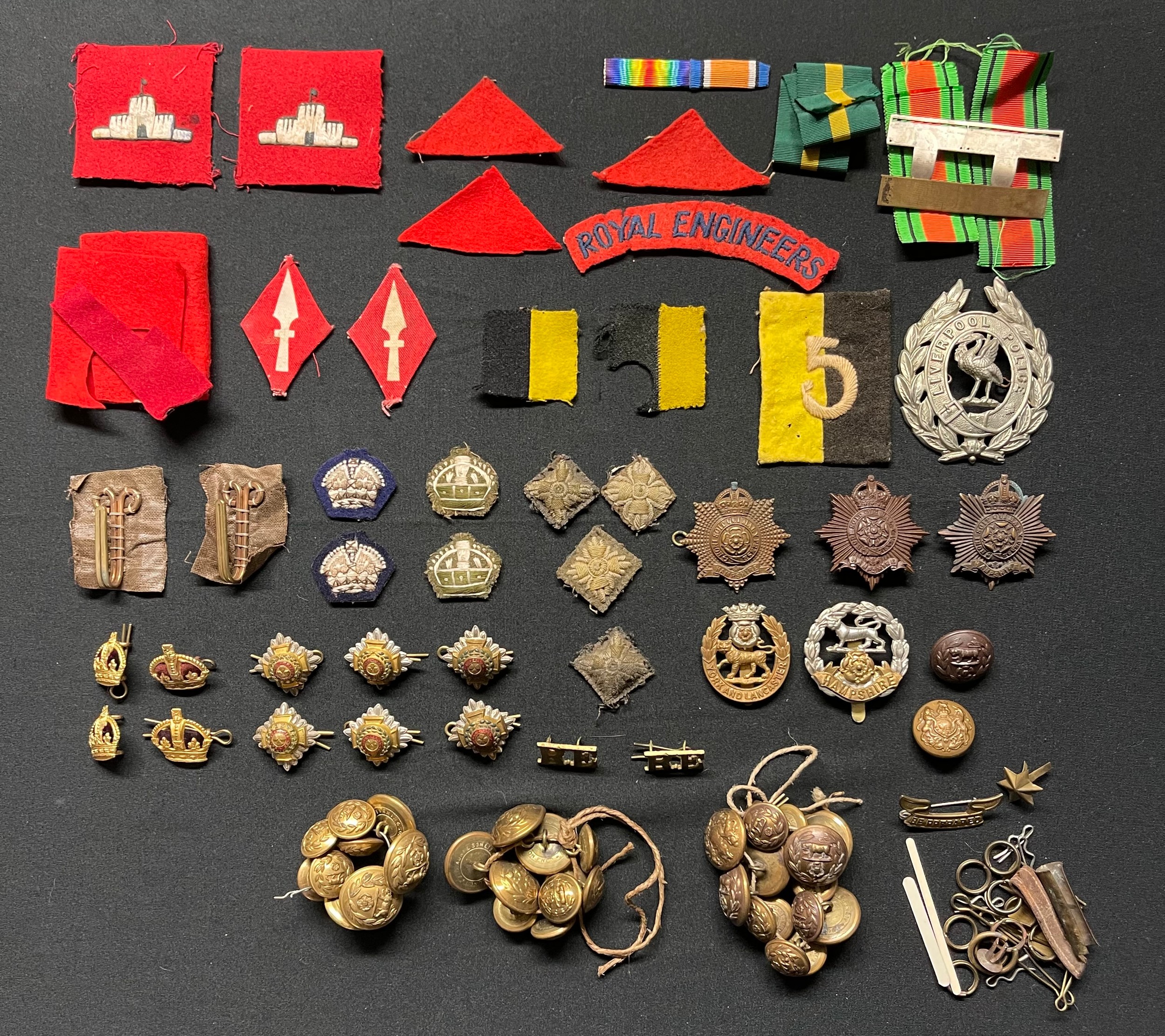 WW2 British cap badges and insignia to include three Hampshire Regiment Officers cap badges, York & Lancaster Regt cap badge, regimental pattern buttons, formations signs, rank pips and Major's rank crowns, cloth rank insignia, single RE shoulder title, Victorian Liverpool Police Helmet Plate, medal ribbons, ribbon bars, etc