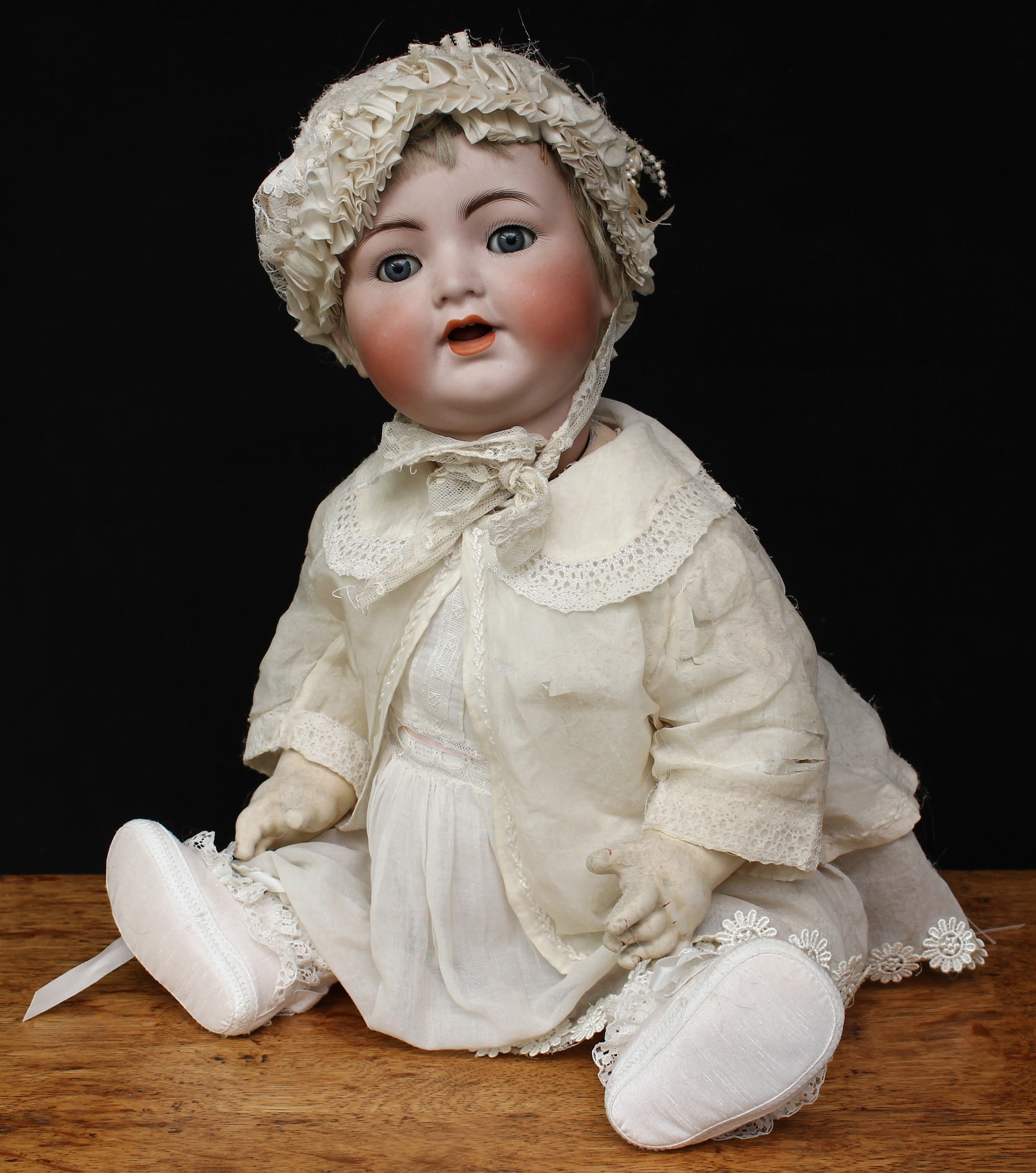 A Simon & Halbig (Germany) bisque head and composition bodied doll, weighted sleeping blue glass eyes, painted features including fine eyelashes and brown feathered eyebrows, open mouth revealing teeth and wobbly tongue, blonde wig, impressed marks ‘SIMON & HALBIG 126 GERMANY 56’, the torso fitted with crying voice box, 53cm high