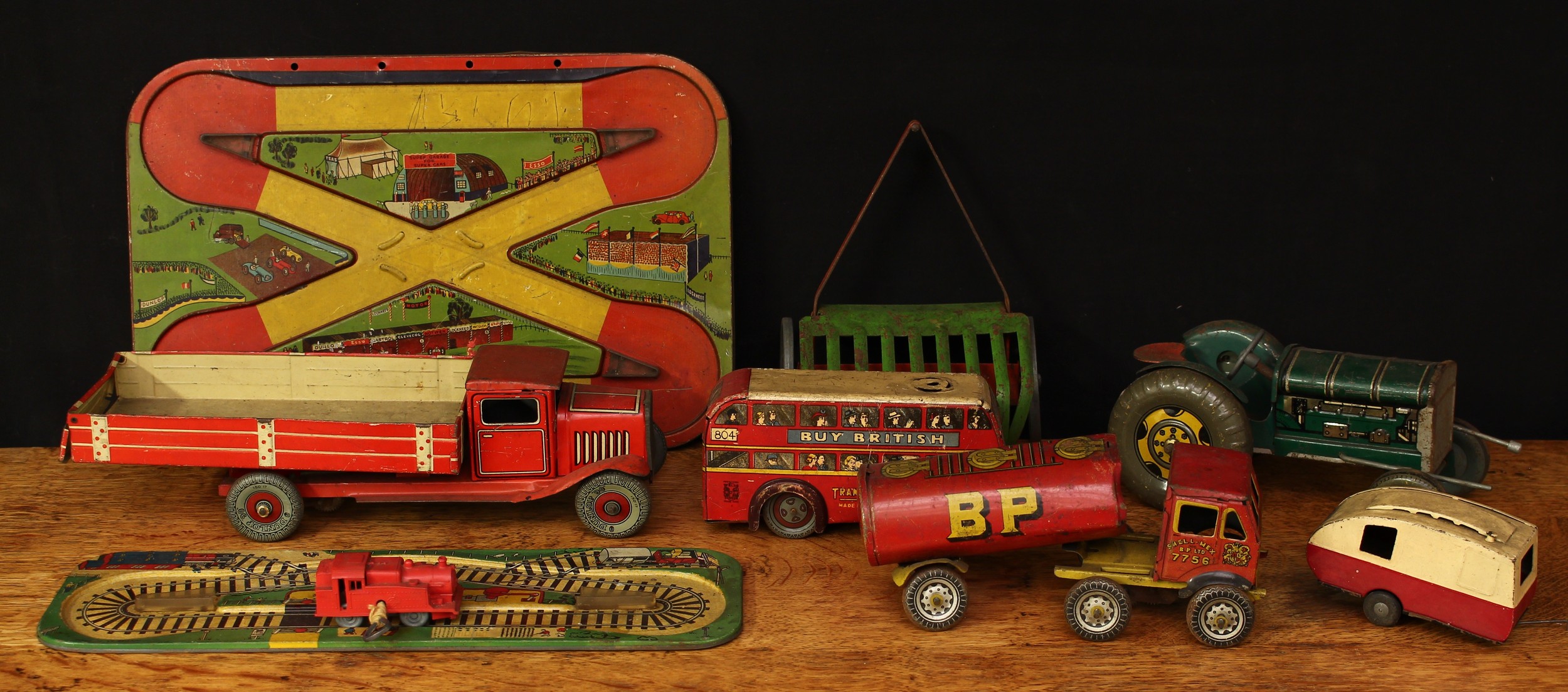 A collection of 20th century tinplate and plastic toys, comprising a tinplate and fixed key wind tipper truck, 31cm long, unboxed, probably by Mettoy; a tinplate and fixed key wind petrol tanker, “SHELL MAX BP LTD”, 20cm long, unboxed, probably by Mettoy; others tinplate toys including Tri-ang Minic, all unboxed (quantity)