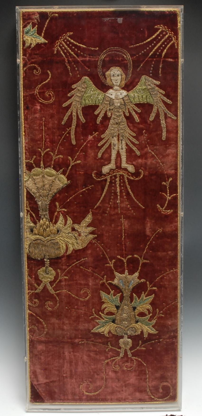 A panel of Italian Renaissance velvet applique embroidery, worked coloured wool and metal thread couched in chevron with an angel symbolism, later mounted 69.5cm x 27.5cm, probably Genoa, c.1480 - 1550