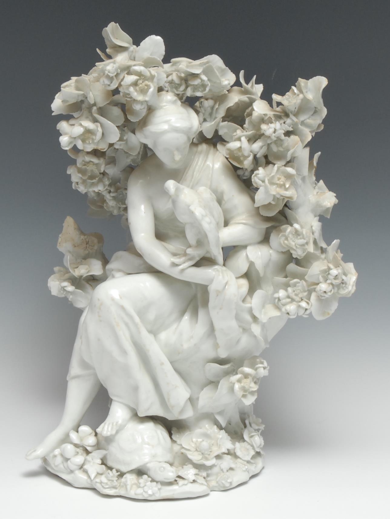 A large Chelsea figure, Emblematic of Touch, from the Senses, of a lady seated holding a hawk, resting her foot in a tortoise, before bocage, in the white, 34cm high, red anchor period c.1752  A similar allegorical figure is illustrated in "English Porcelain Circle Transactions," No. II (1929) from the Alfred Hutton Collection