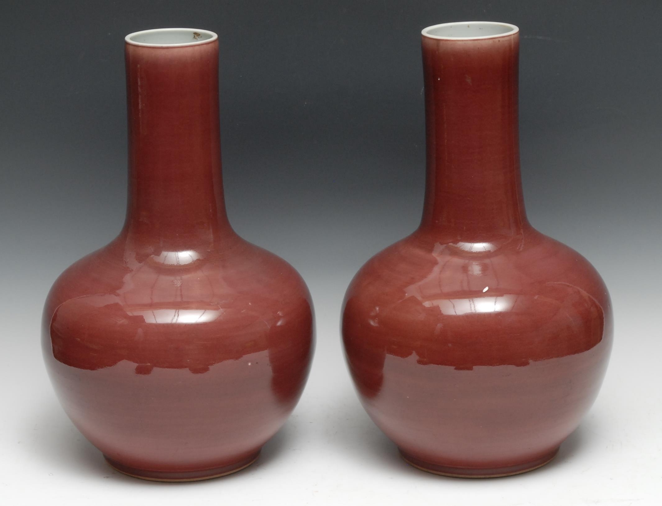 A tall pair of Chinese Sang de Boeuf porcelain globular vases, glazed in merging tones, Blanc de Chine interior, 37.5cm high, 19th century