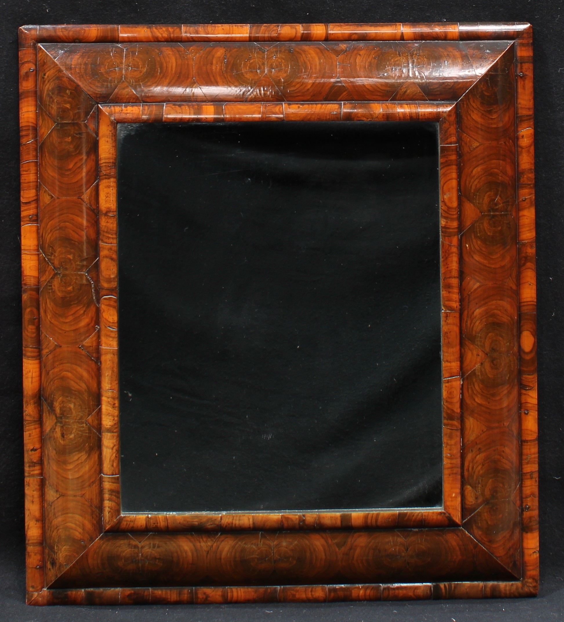 A William and Mary oyster veneer rectangular cushion mirror or looking glass, 77.5cm high, 68.5cm wide overall, c.1690
