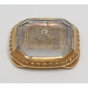 A late 17th/early 18th century gold coloured metal,  rock crystal and plaited hair canted rectangular momento mori mourning slide, decorated with skull-and-crossbones and initials AS, 2cm wide, c.1700, 8g gross