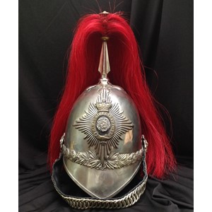 British Victorian 1871 Pattern Hampshire Carabiniers Cavalry Helmet. Silvered skull with some period repairs. White metal star helmet plate being the Regimental badge with Queens Crown. Helmet has silvered metal cross base and fluted plume holder which houses a falling red plume. Gilt metal rosette to top of holder. Silvered rosettes which secure a replacement black leather backed chin chain. Green leather to underside of the peak. Original brown leather liner with a section missing. Small size.