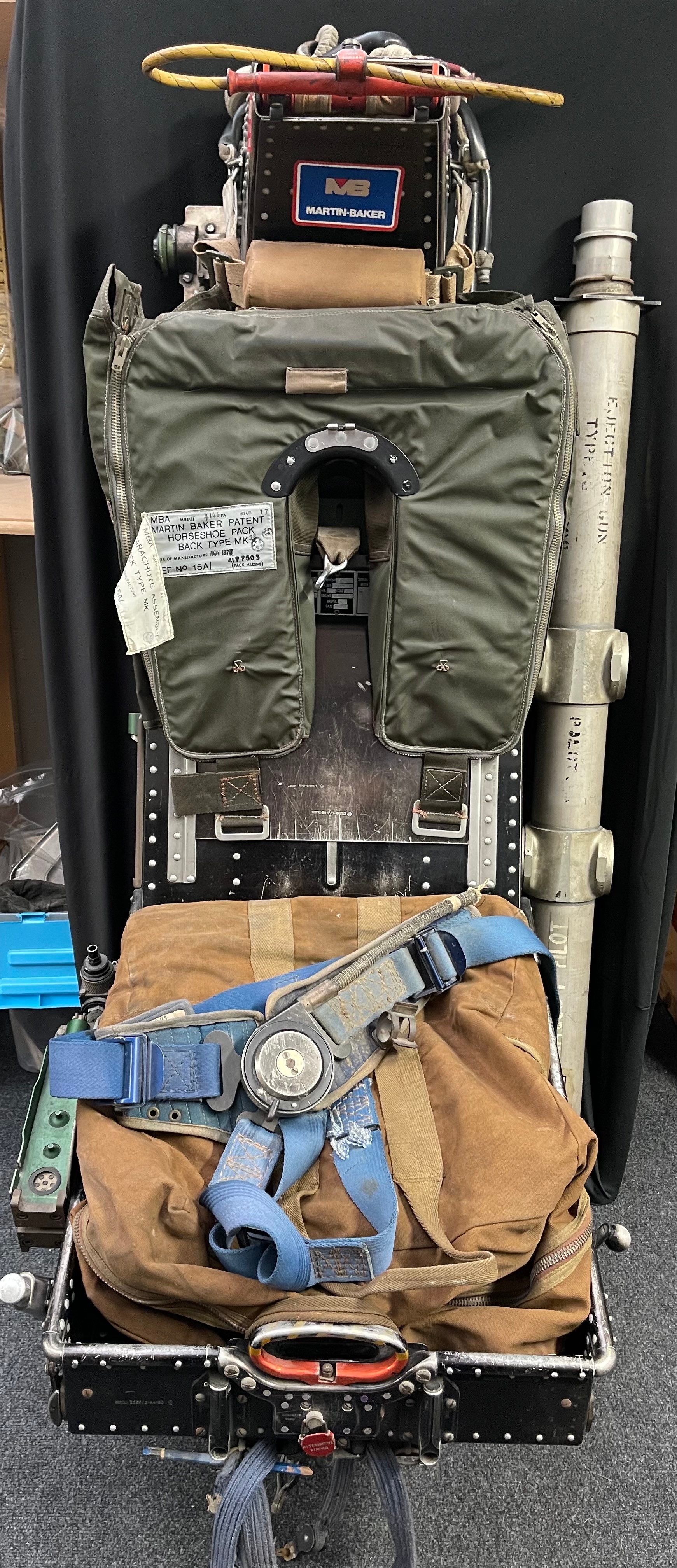 RAF Martin Baker MK 3JS Ejector seat taken from Gloster Javelin Jet Fighter Serial Number XJ117. This aircraft was built in 1960 and scrapped in 1974. The seat itself is serial no 364 and is dated 19-11-59. It is in unrestored original condition as it came out of the aircraft. It is complete with all data plates. The drogue parachute is complete in it's pack. There is a canvas head rest with webbing straps. It is marked as "Front XJ117" in two places. The seat has some other components still in place. Levers and knobs move correctly. It is covered in inspection stamps. In addition to the seat there are some other items in this lot to include: an Ejector Gun Tube Type 3 ref 27.L.368 which is marked "XA899 1st Pilot" taken fron Avro Vulcan V Bomber XA899 which as built in 1955 and scrapped in 1967. INERT & FFE: a Air Ministry marked parachute/kit bag: A Martin Baker Patent Horseshoe Pack back type Mk28 dated Nov 1978/Parachute assembly back type Mk44A. This also marked "Binbrook Lightning Feb 85": two small Parachute or Harness straps.