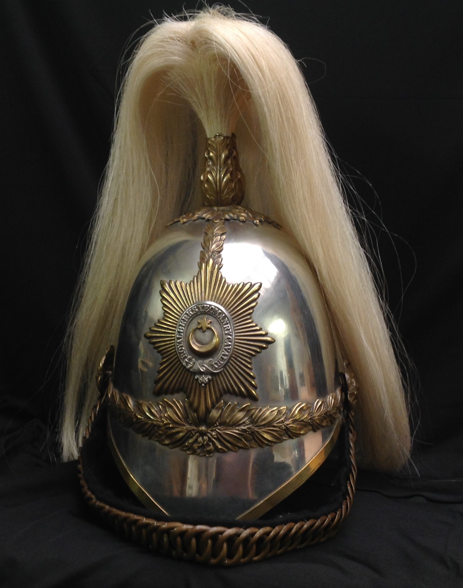 British Victorian 1871 Pattern Royal Berkshire Yeomanry Cavalry Helmet. Silvered skull. White Horse Hair Falling plume, missing boss. To each side, a brass rose head boss supports a modern replacement black felt backed brass chin chain. To the front is the helmet plate bearing the Regimental badge of Star & Crescent on a star backing. Black leather liner.