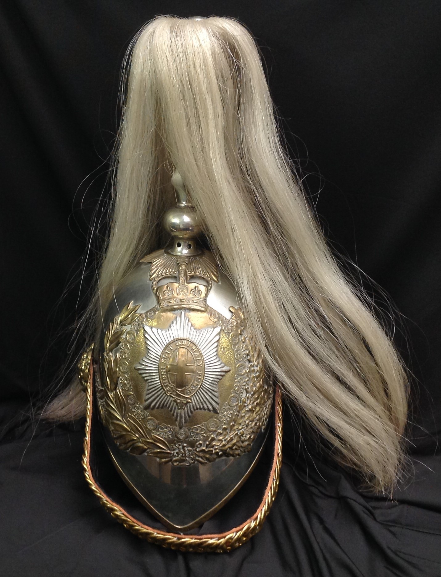 British Victorian 1871 Pattern Life Guards  Helmet. Silvered skull. To the top of the helmet is a gilt acanthus leaf holder which supports the falling white horse hair plume. Gilt rose pattern ear bosses, support a modern replacement gilt brass leather backed chin chain. To the front is the helmet plate of a half laurel and half oak leaf wreath surrounding the collar of the Order of the Garter and surmounted by a Queens Crown. The liner is a modern 20th Century replacement in tan coloured leather.