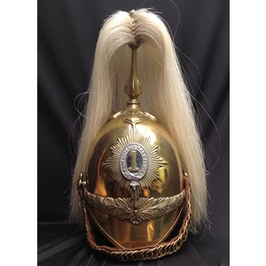 British Victorian 1871 Pattern Cavalry  Helmet. Brass skull with 1st Dragoon Guards regimental helmet plate to front. Helmet has brass cross base and fluted plume holder which houses a falling white horse hair plume. Gilt metal rosette to top of holder. Brass rosettes (one of which is a replacement and is loose having incorrect thread) which hold a replacement chin chain backed with brown felt. Brown leather liner which bears a paper size label which reads "6 1/2". Green leather to underside of peak.