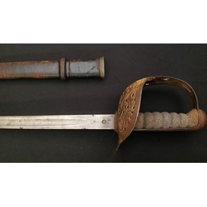 WW1 British 1897 pattern Officers Sword with single edged fullered blade 820mm in length. Proof marked. Maker marked "Henry Wilkinson, Pall Mall, London". Etched decoration to blade has 1 inch calibrations starting at 10 and ending at 36. Serial number to spine of blade 35967. Guard with GR V cypher. Shagreen grip, but missing grip wire. Overal length approx 985mm. Complete with leather covered scabbard.