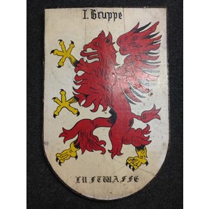 WW2 Third Reich Luftwaffe Hand Painted Plaque with the insignia of I Gruppe, Lehrgeschwader 1. Size 605mm x 397mm. Reverse has handwitten penciled inscription "4 G 1" along with "Uffz Stuchli K mitnehmen". Wood is 20mm thick. Two screws to which a length of electrical wire is attached for hanging. Weight 3.6kgs.