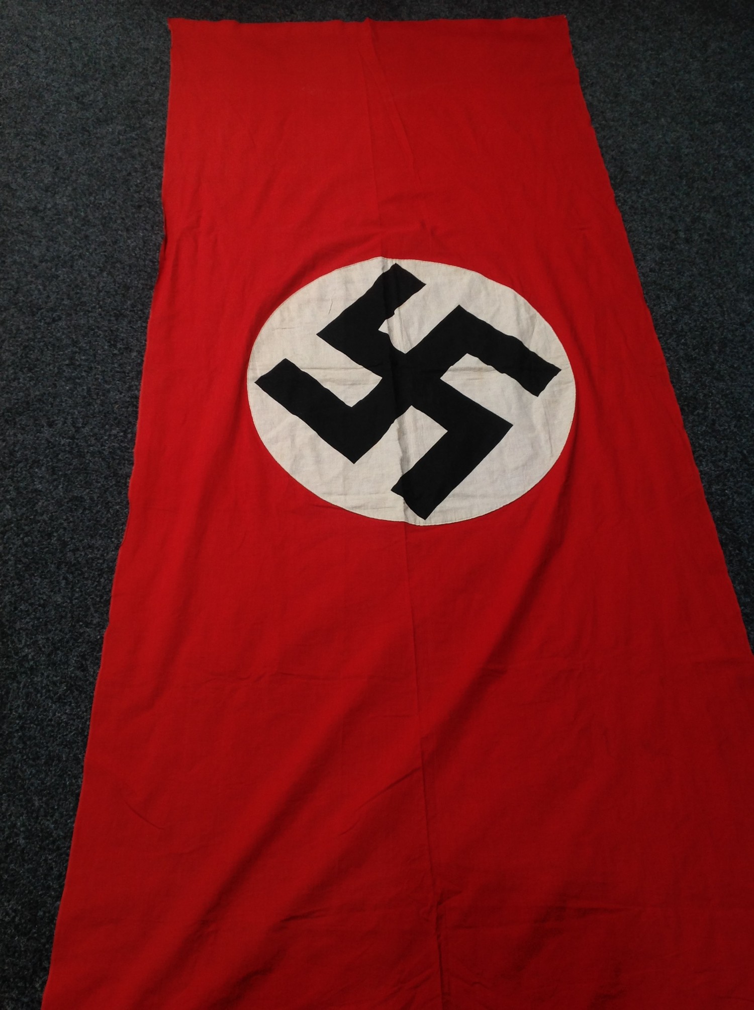 WW2 Third Reich NSDAP Banner, size 280cm x 116cm. Printed Swastika on a separate white roundal. No makers markings. Has provision for a wood or metal rod for hanging.