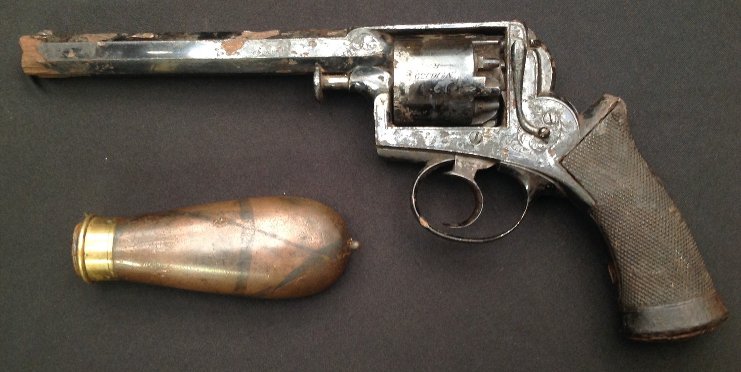 Dean & Adams 1851 Patent Perscussion Cap Revolver. Serial number to frame "7095". Five shot cylinder. .456 bore. Action a/f. Barrel length 160mm. Overall lenth 290mm. Backstrap maker marked "Deane Adams & Deane, 30 King William Street, London Bridge". Frame marked "Adams Patent No.." Cyclinder marked "No.10.139 R ". Along with a Copper and Brass powder flask, missing the nozzle. No makers marks. The revolver has heavy rust pitting overall, but does still exhibit some original finish. Section 58, no licence required. (2)