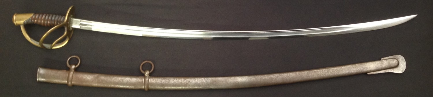 US Civil War 1864 Pattern Cavalry Sabre with curved fullered single edged blade 885mm in length. Marked "US 1864 A.G.M" plus maker marked "C Roby, W Chelmsford, Mass". Washer present. Brass guard. Grip wire missing. Overall length 1040mm. Complete with scabbard with twin suspension rings.