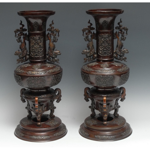 A pair of large Japanese brown patinated bronze vases, cast with temple lions, scrolls and lappets, 44cm high, Meiji period