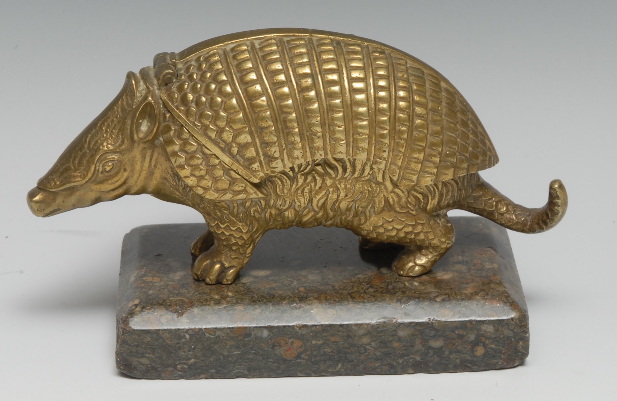 A 19th century bronze novelty animalier encrier, cast as an armadillo, hinged cover enclosing a pair of inkwells, rectangular marble base, 18cm wide