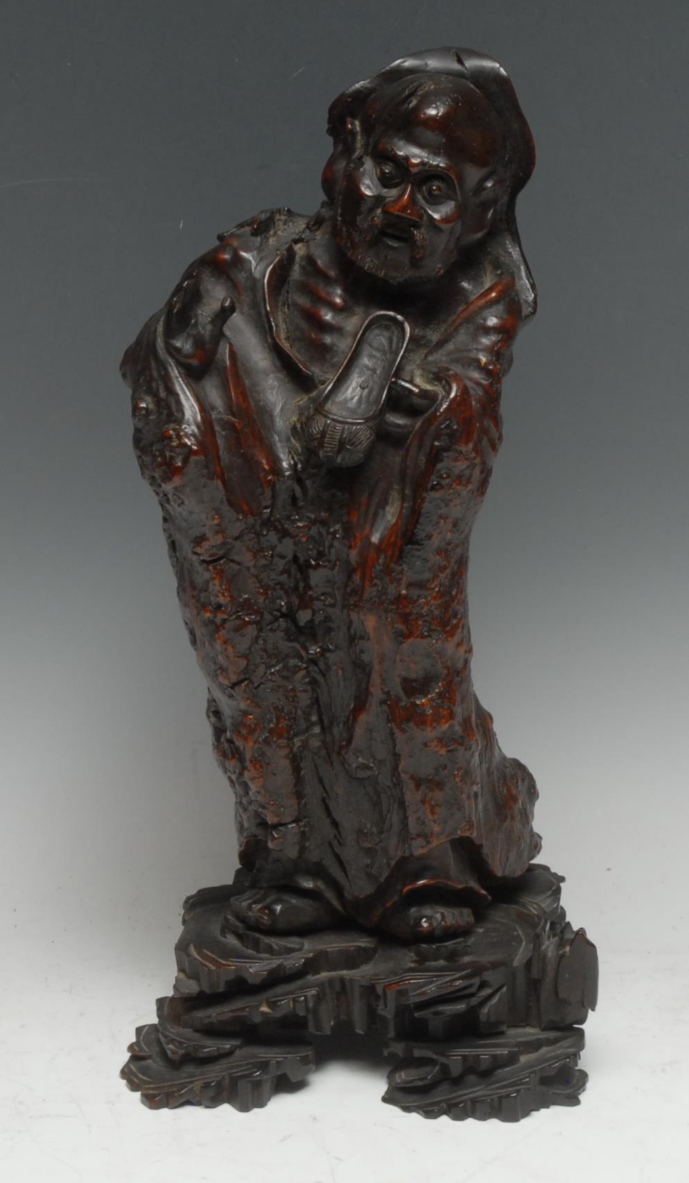 A Chinese rootwood carving, as an elder holding a shoe, 37cm high, 19th century