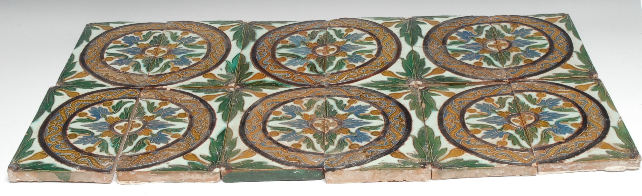 A collection of South European tiles, comprising a scheme of five pairs, glazed in tones of green, blue and yellow, each 13.5cm x 22cm (10)