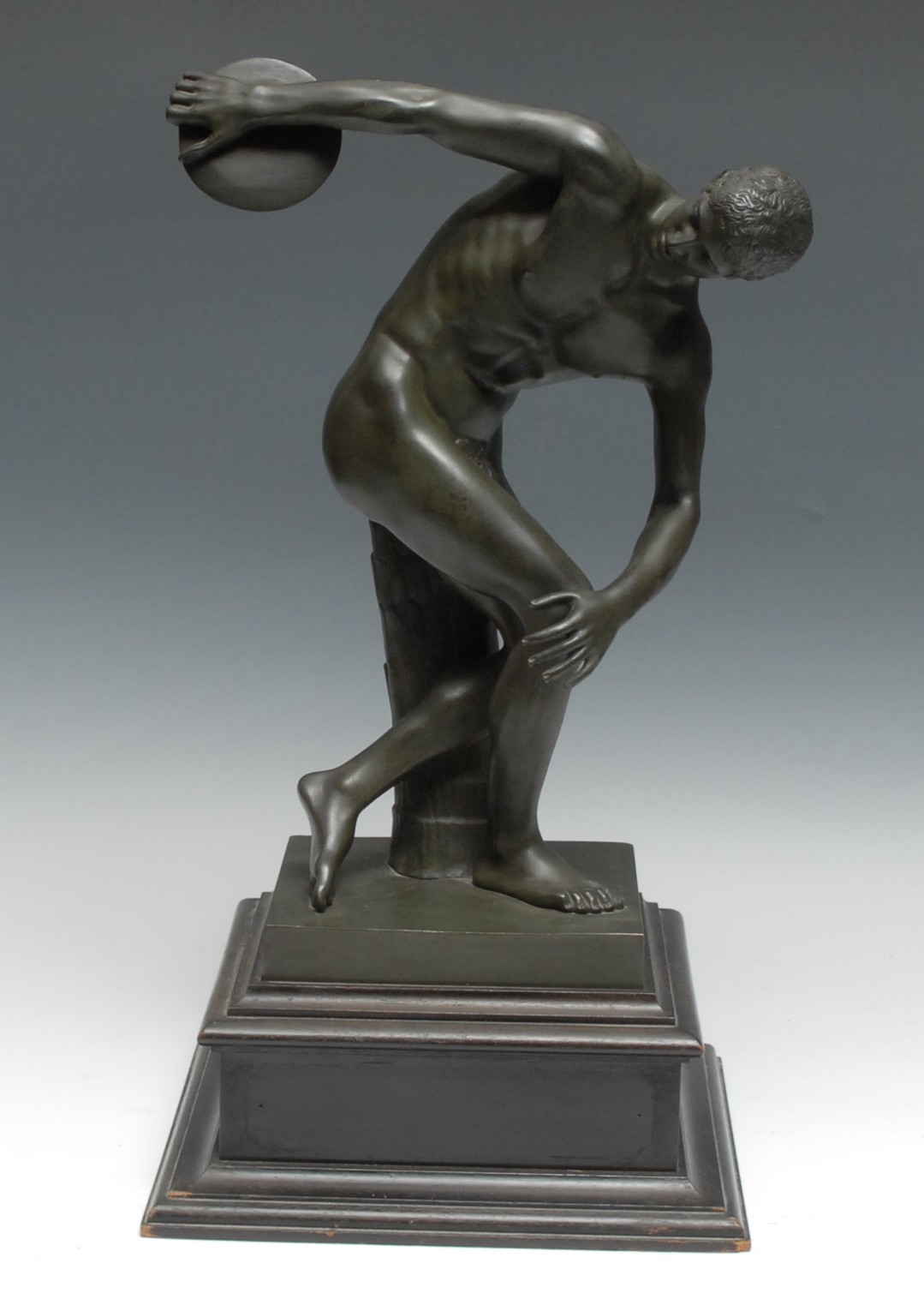 Grand Tour School (19th century), after the Antique, a verdigris patinated library bronze, The Discobolus of Myron, inscribed in the maquette Musee du Vatican, 39.5cm high, ebonised plinth, 49cm high overall