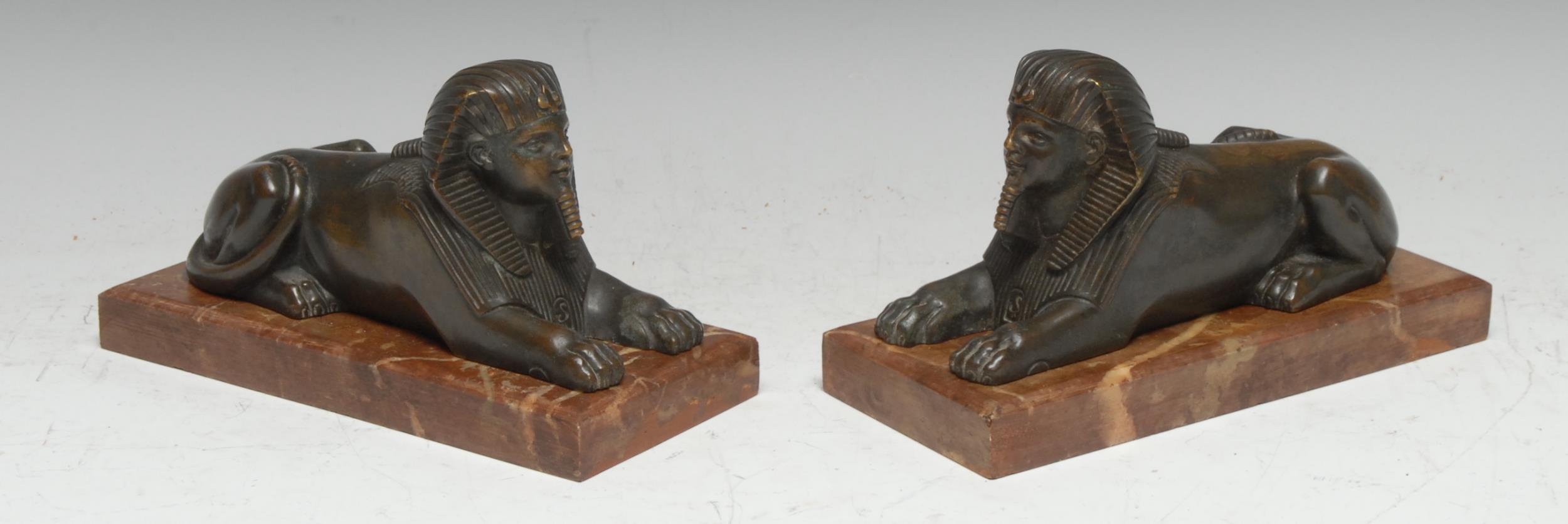 French School (19th century), a pair of Egyptian Revival bronzes,each cast as a sphinx, rectangular marble bases, 18cm wide