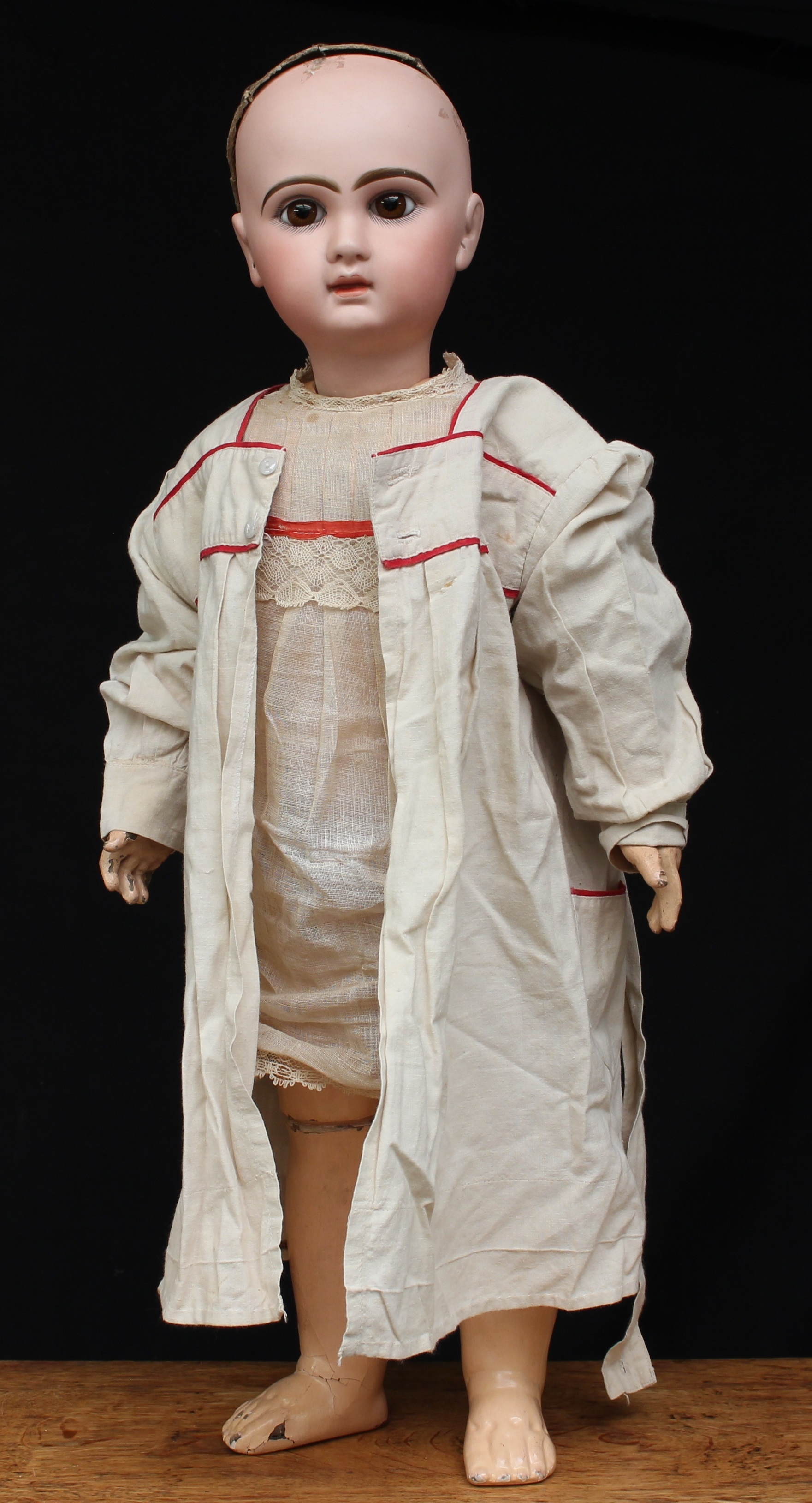 A large Dèposè Tete Jumeau bisque head and painted composition Bèbè, size 12, inset fixed brown glass eyes, painted features including fine eyelashes, brown feathered eyebrows and moulded red lips, pierced ears, cardboard pate, red printed marks to back of head 'DEPOSE TETE JUMEAU BTE S.C.D.G. 12' and blue printed mark to lower back 'BEBE JUMEAU', 65cm high