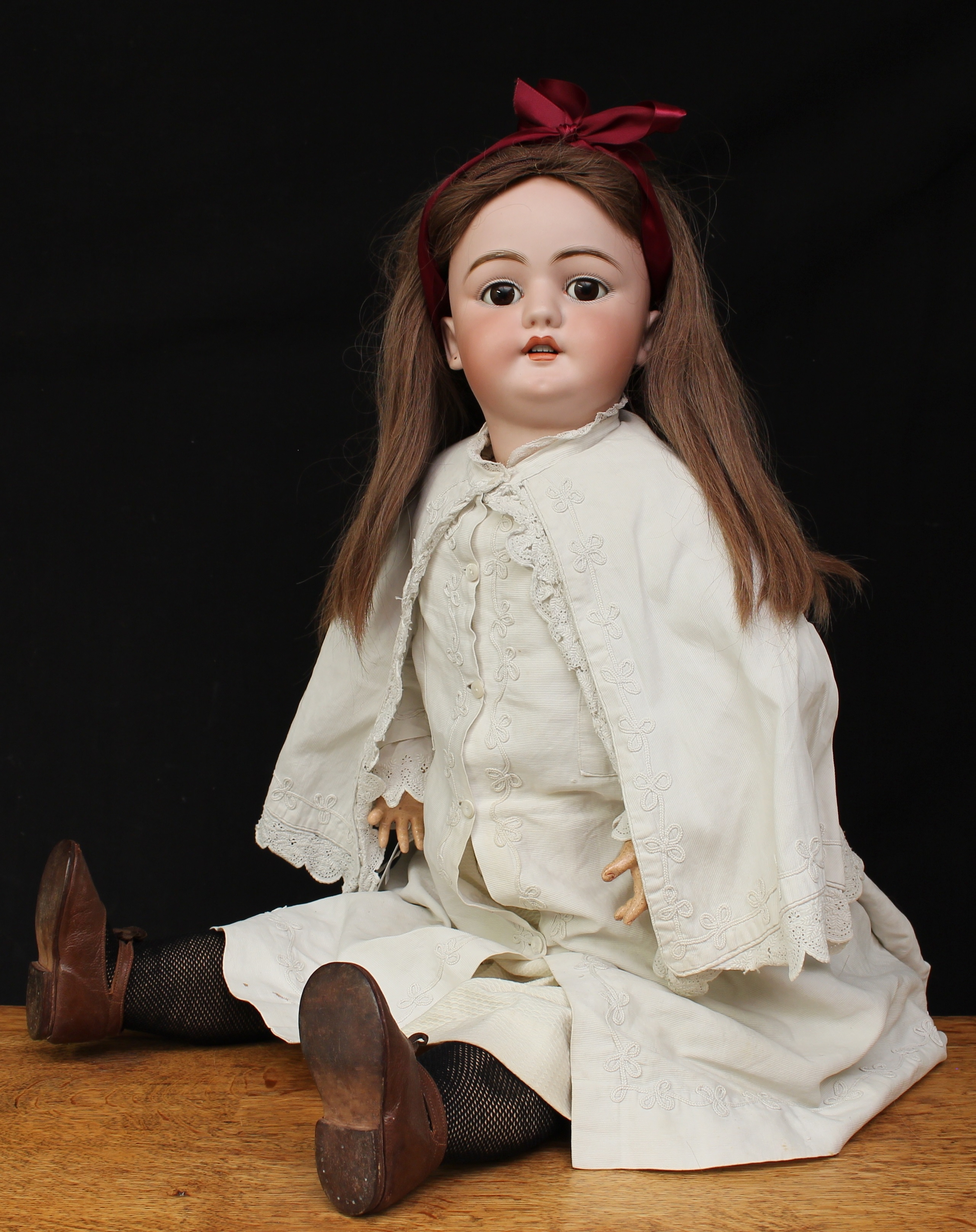 A large Simon & Halbig (Germany) bisque head and painted composition bodied doll, weighted brown glass eyes, painted features including fine eyelashes and brown feathered eyebrows, open mouth revealing teeth, pierced ears, brown wig, impressed marks 'SH 1019 DEP 15', 85cm high