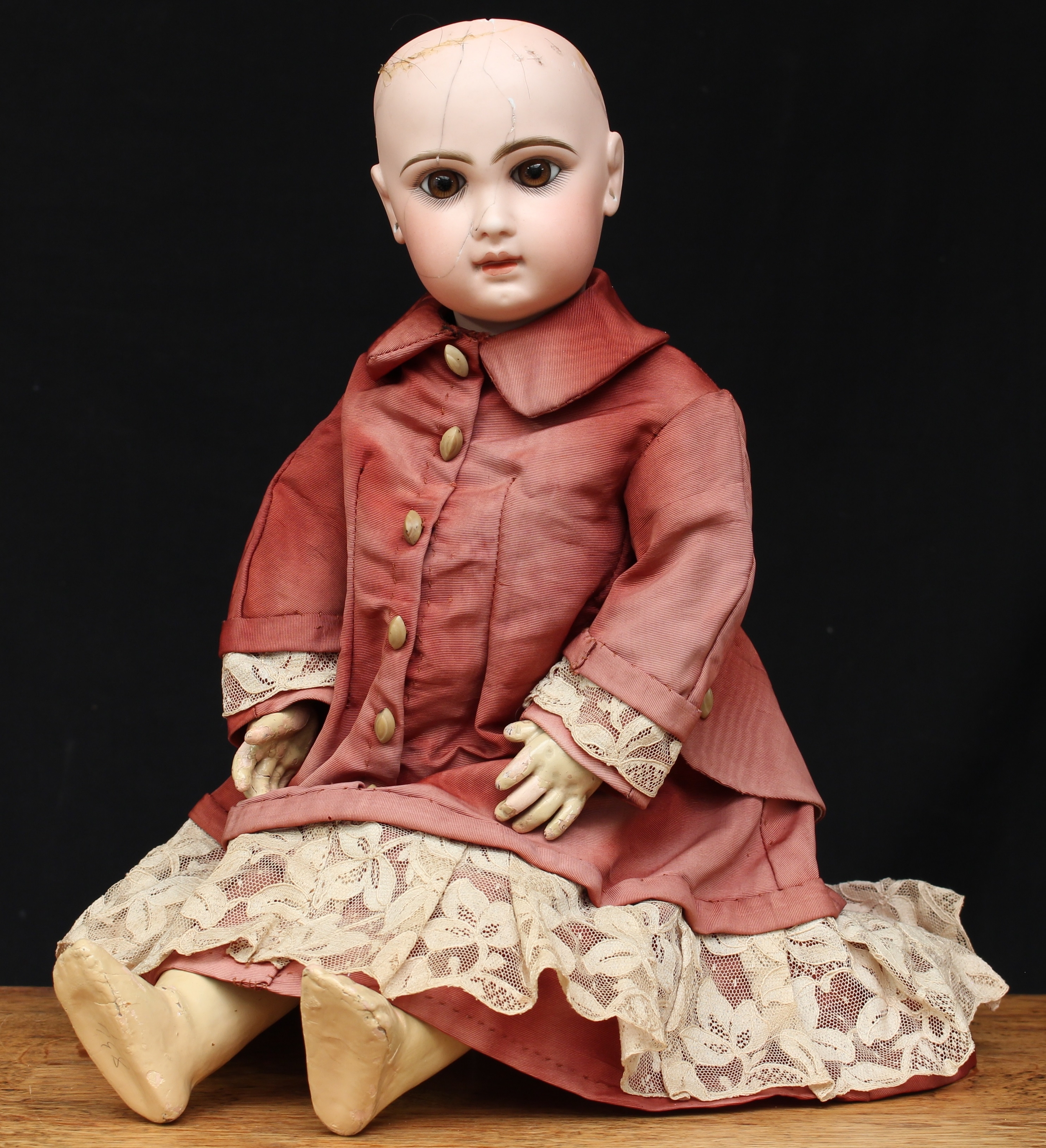 A Dèposè Tete Jumeau bisque head and painted composition Bèbè, size 8, inset fixed brown glass eyes, painted features including fine eyelashes, brown feathered eyebrows and red lips, pierced ears, red printed marks to back of head 'DEPOSE TETE JUMEAU BTE S.G.D.G. 8', the torso fitted with voice box, wearing a red silk dress with lace edge, 46cm high