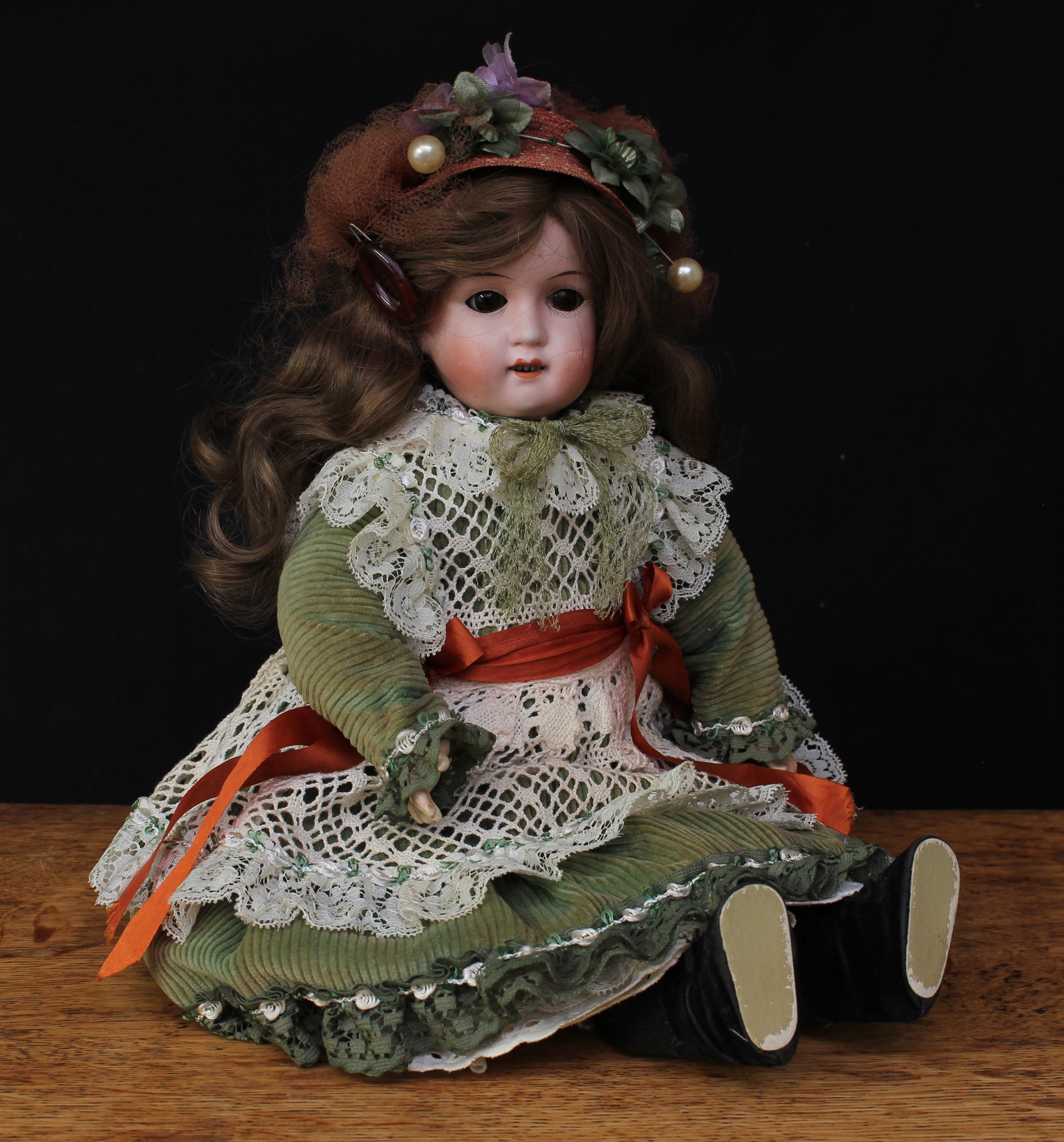 A William Goebel (Germany) bisque head and ball jointed painted composition bodied doll, brown glass eyes, painted features including fine eyelashes and brown eyebrows, open mouth revealing teeth, brown wig, impressed marks 'WG 120 2/0X GERMANY', 43cm high